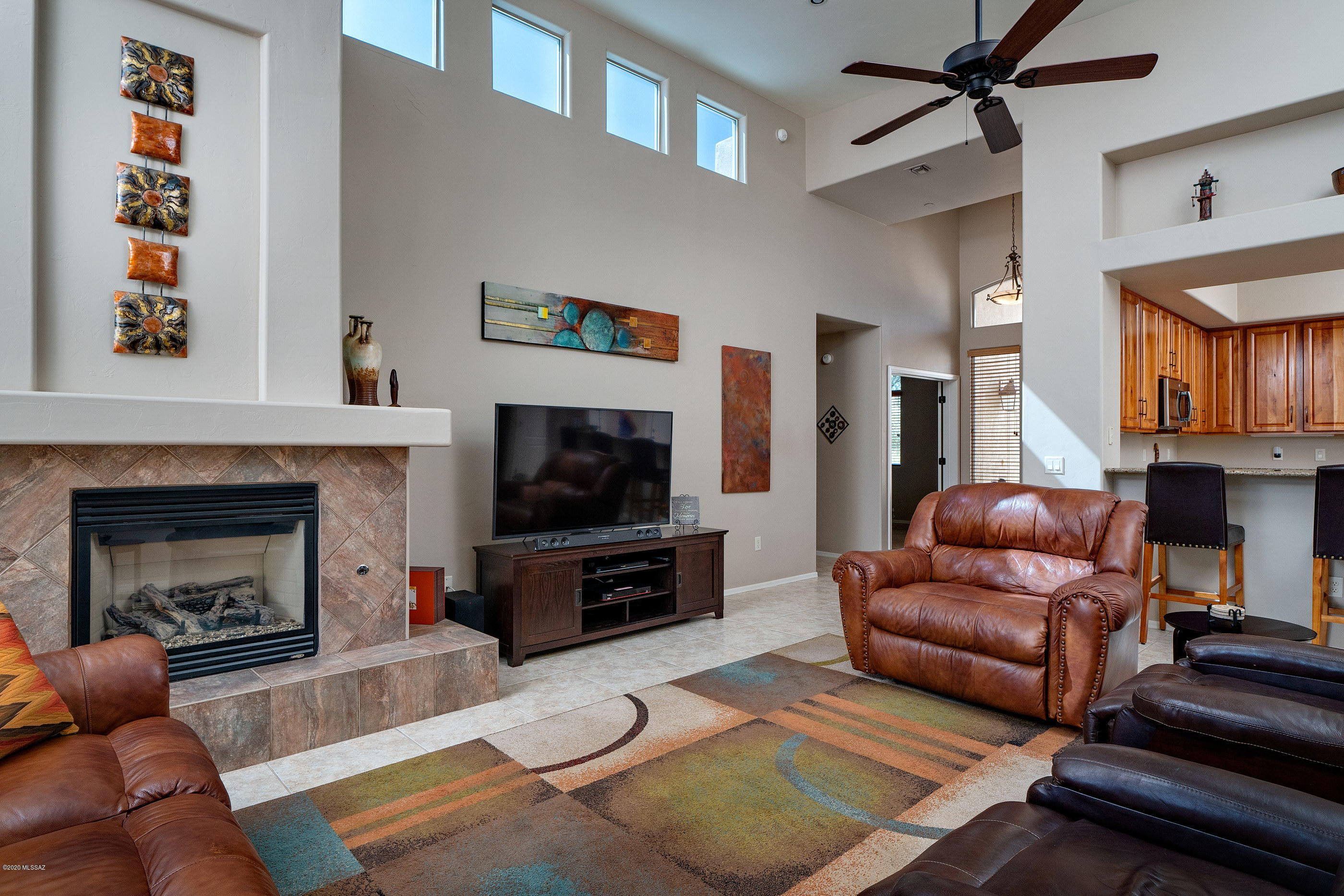4440 West Crystal Ranch Place Marana, AZ 85658 - Photo 10 of 28 a living room with furniture a flat screen tv and a fireplace