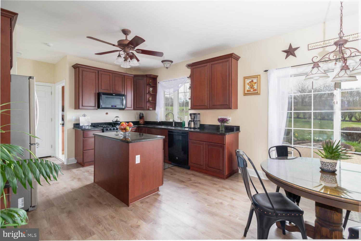 1026 Creamery Road Perkasie, PA 18944 - Photo 22 of 45 a kitchen with stainless steel appliances granite countertop a refrigerator a stove a sink a dining table and chairs with wooden floor