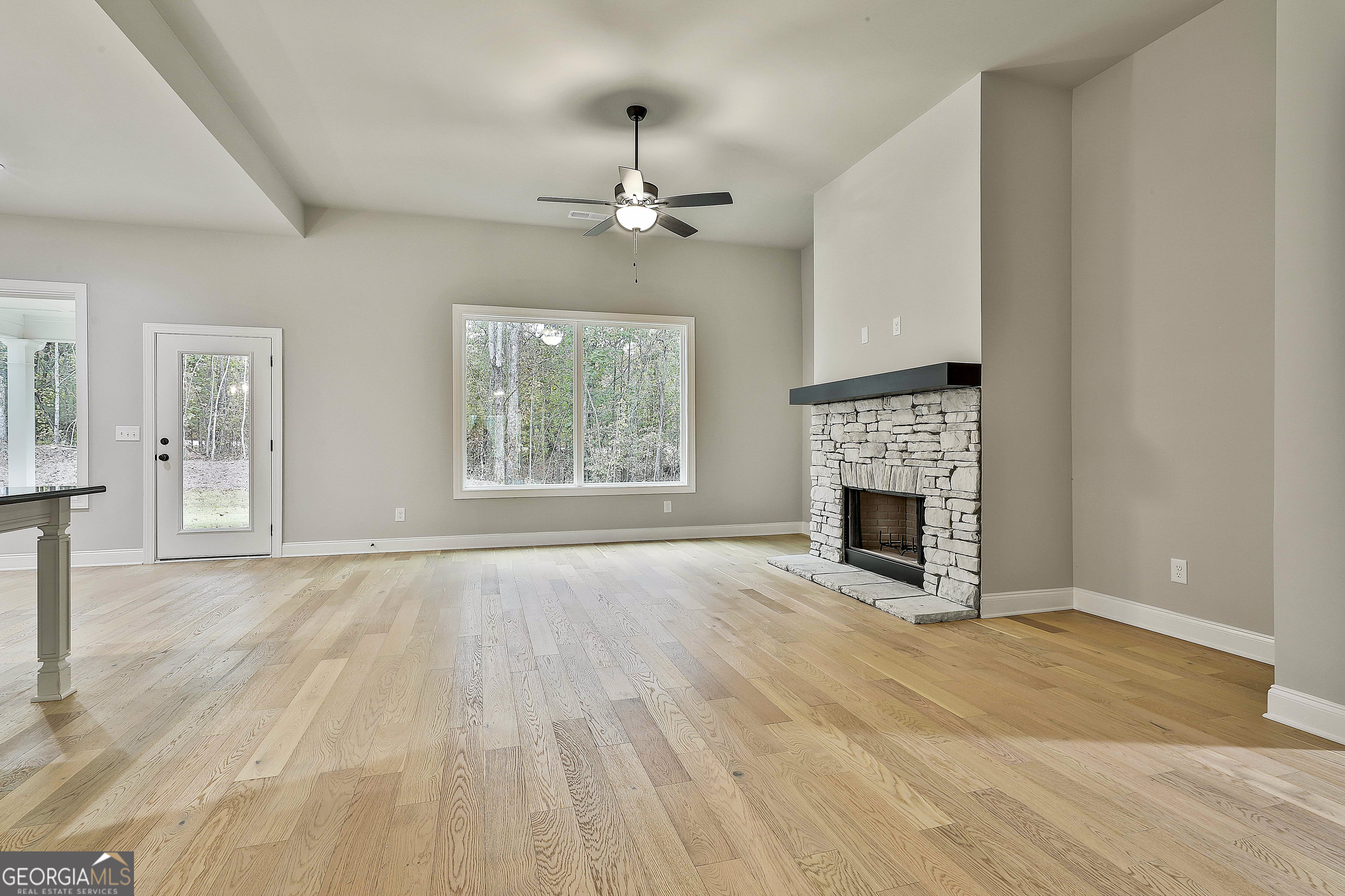 152 Wet Wood Drive, Unit 10 Fairburn, GA 30213 - Photo 14 of 39 an empty room with windows fireplace and wooden floor