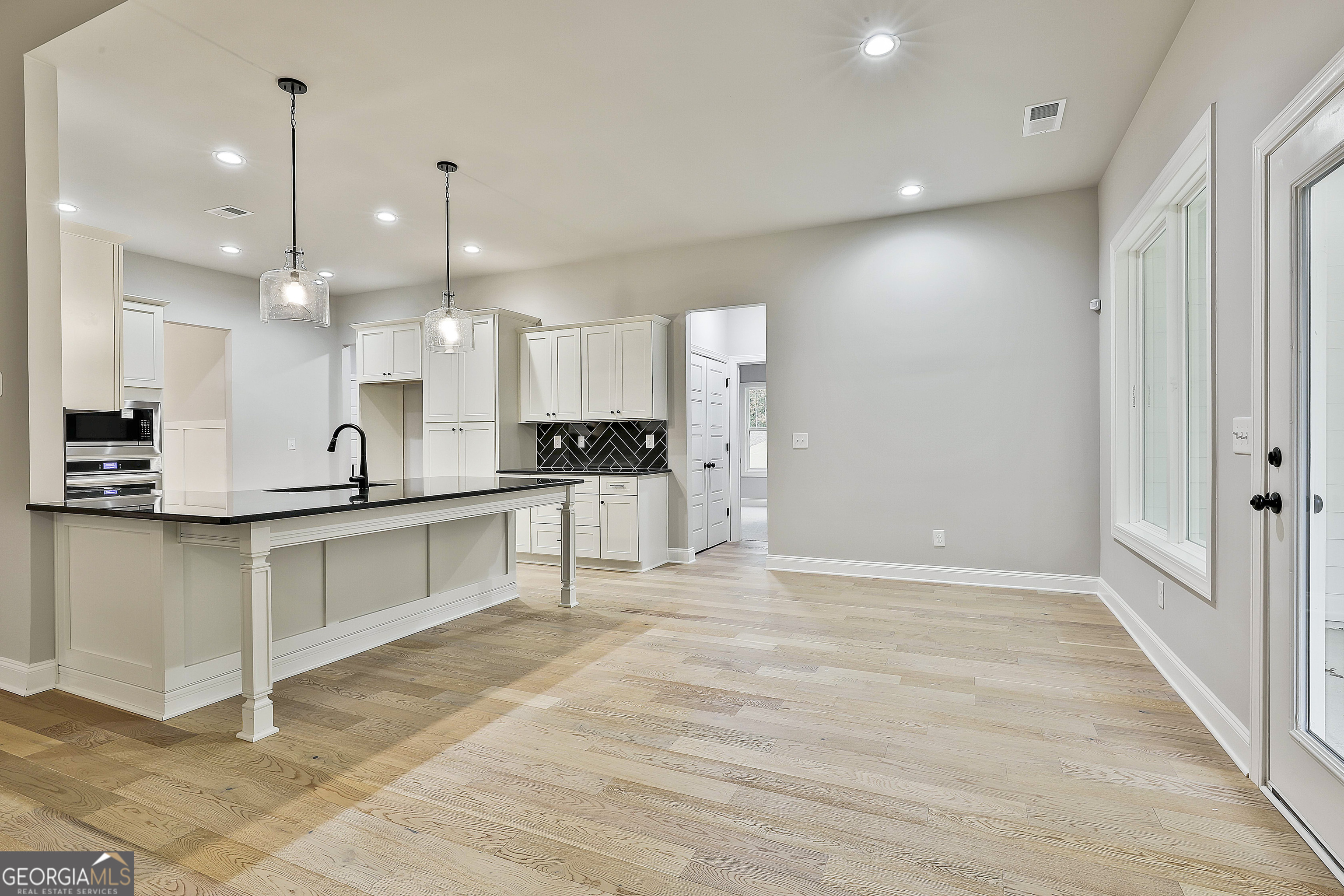 152 Wet Wood Drive, Unit 10 Fairburn, GA 30213 - Photo 18 of 39 a large kitchen with kitchen island a sink stainless steel appliances and cabinets