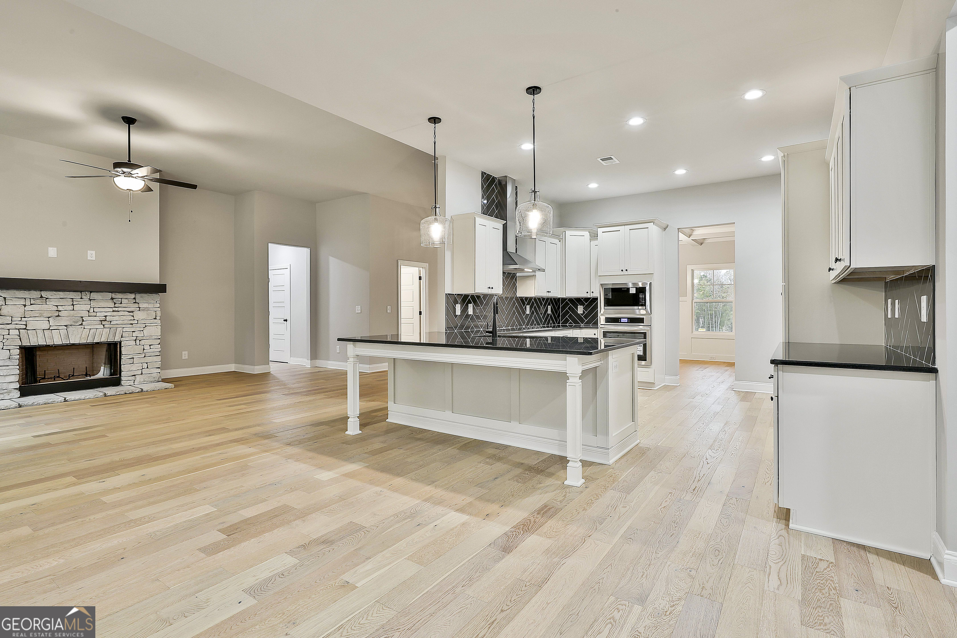 152 Wet Wood Drive, Unit 10 Fairburn, GA 30213 - Photo 19 of 39 a kitchen with stainless steel appliances kitchen island a refrigerator and a stove top oven