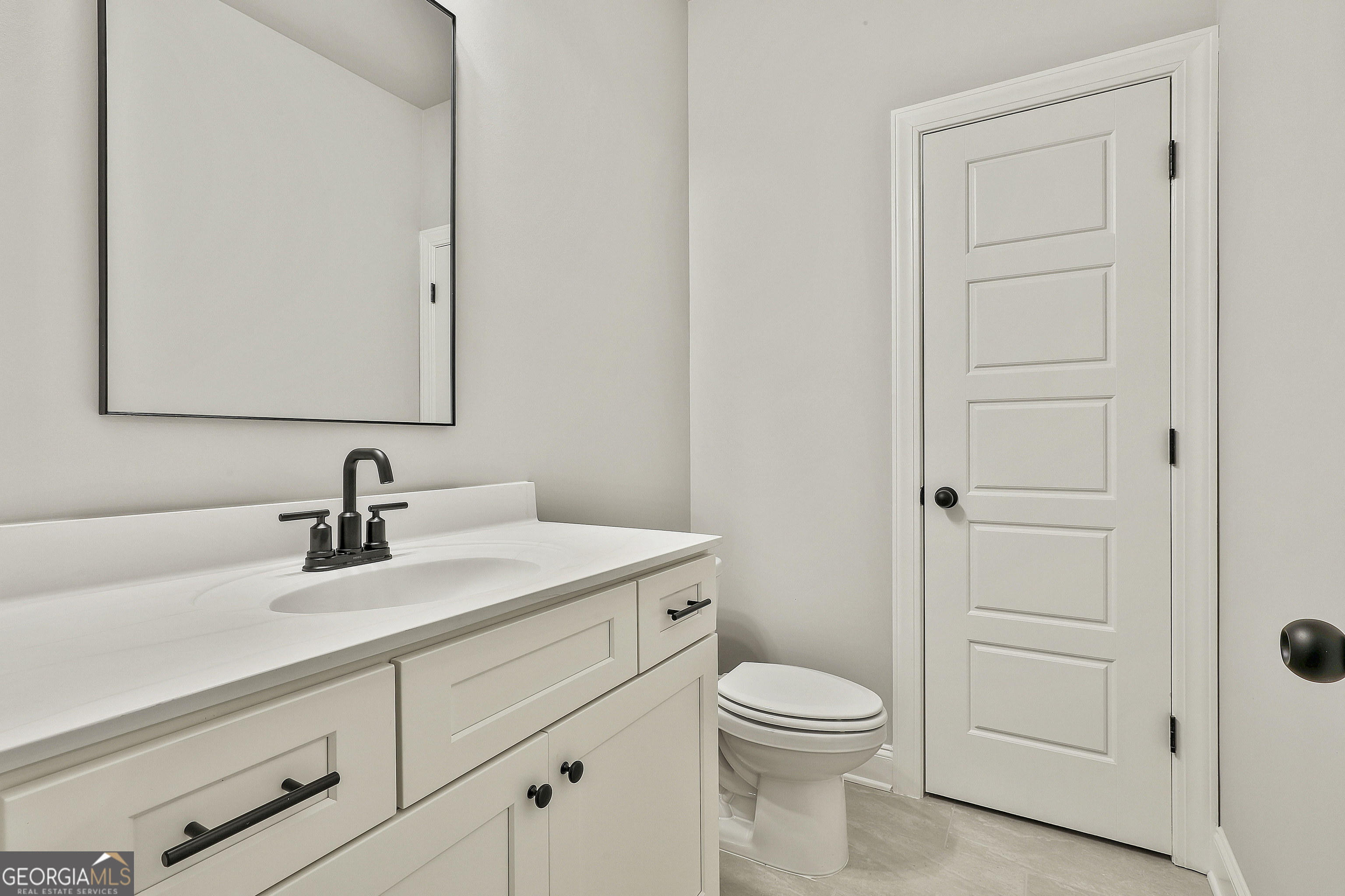 152 Wet Wood Drive, Unit 10 Fairburn, GA 30213 - Photo 26 of 39 a bathroom with a toilet a sink and mirror
