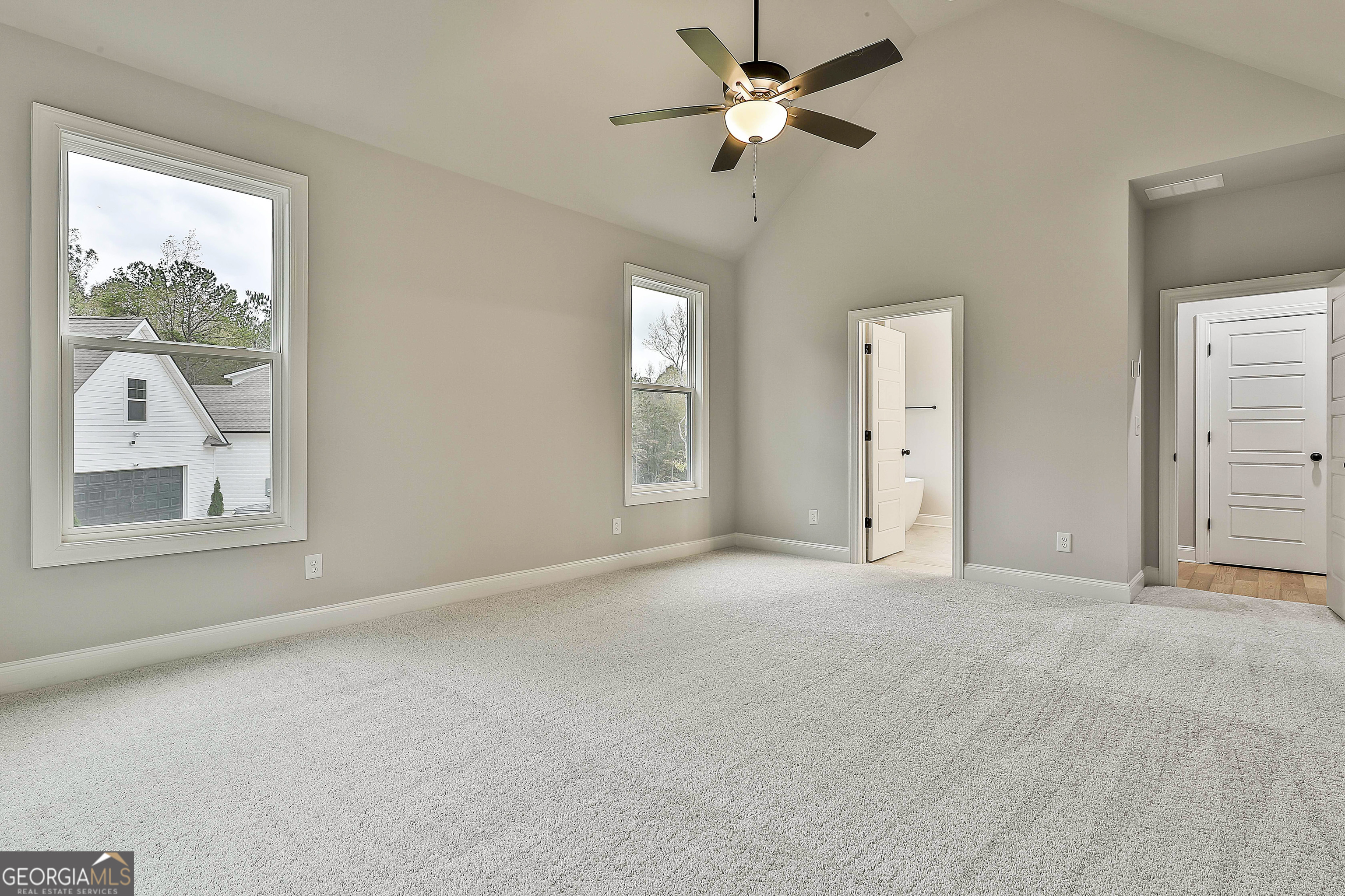 152 Wet Wood Drive, Unit 10 Fairburn, GA 30213 - Photo 28 of 39 an empty room with chandelier fan and windows
