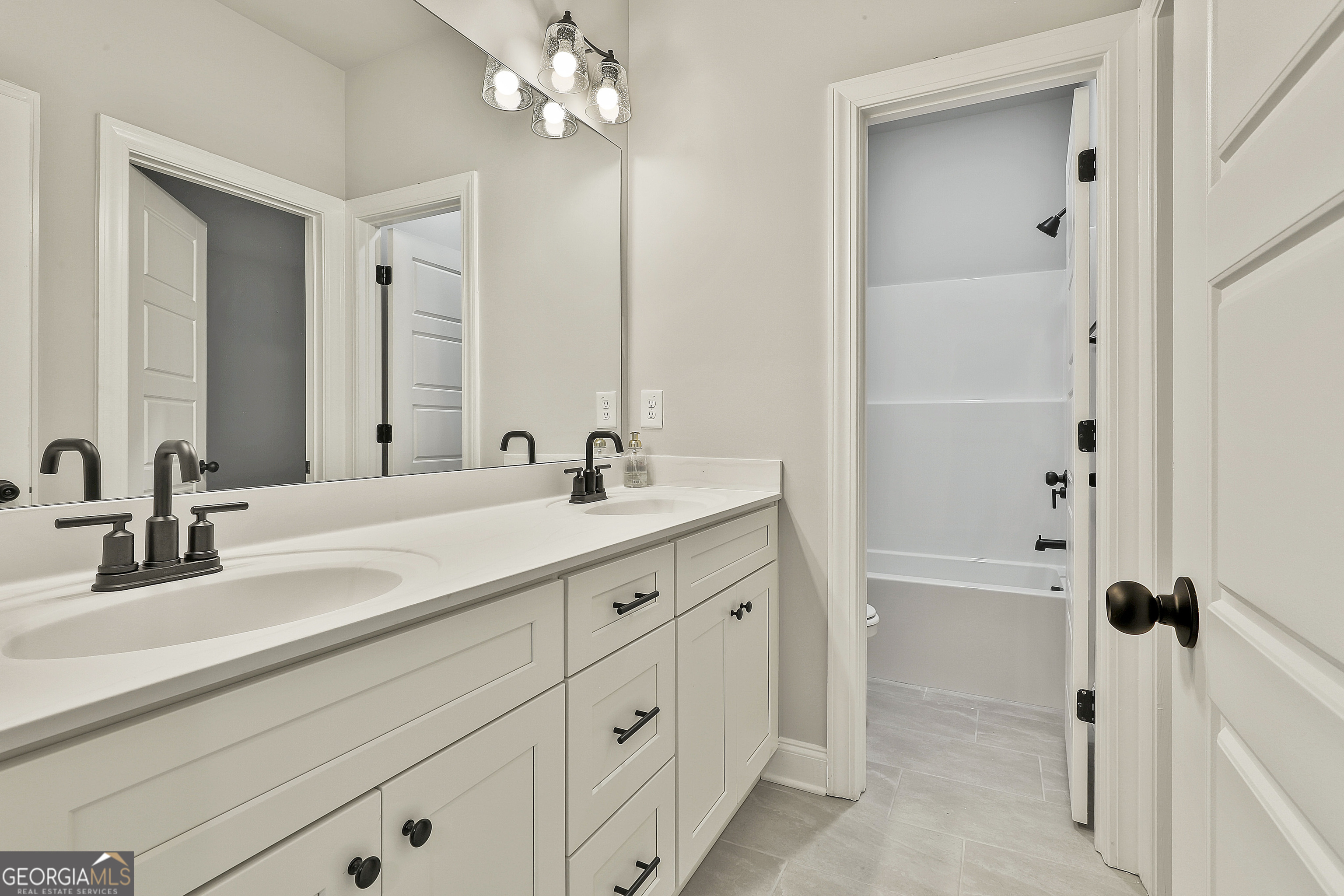 152 Wet Wood Drive, Unit 10 Fairburn, GA 30213 - Photo 33 of 39 a bathroom with a double vanity sink a mirror and shower