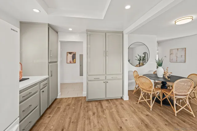 a view of kitchen and empty room with wooden floor