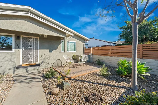 a dining room with furniture potted plants and wooden floor