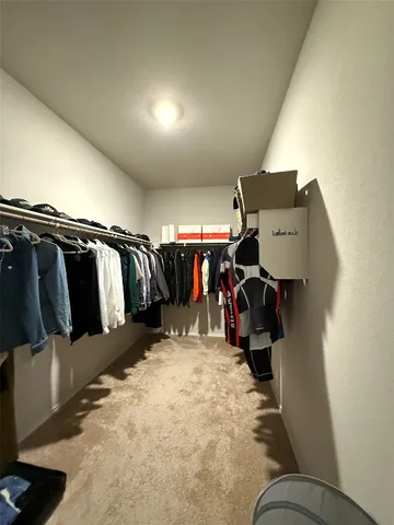 a view of walk in closet with clothes and shoes