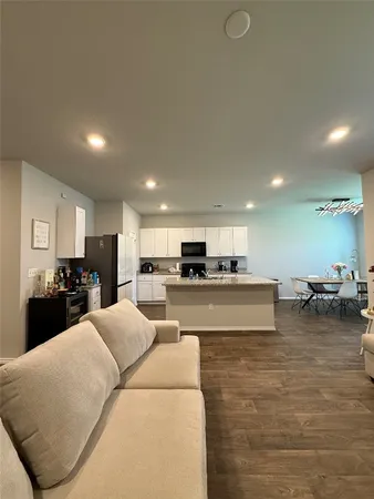 a living room with furniture and a wooden floor