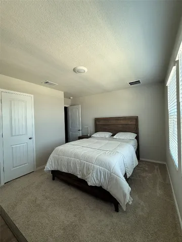 a spacious bedroom with a bed and a window