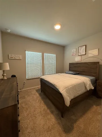 a bed sitting in a bedroom next to a window