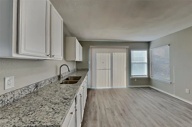 a kitchen with granite countertop a stove and cabinets
