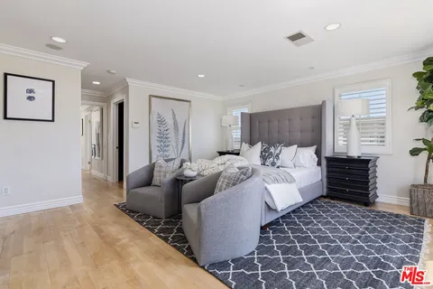 a large bedroom with a bed and wooden floor