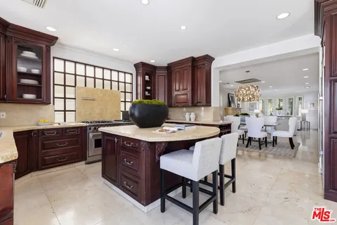 a kitchen with a stove a sink a dining table and chairs