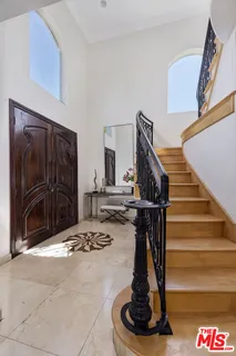 a living room with furniture a potted plant and a large window