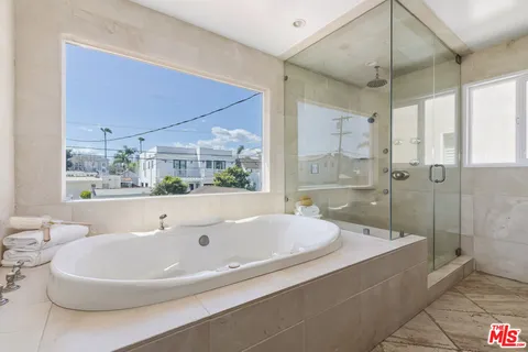 a spacious bathroom with a bathtub and shower