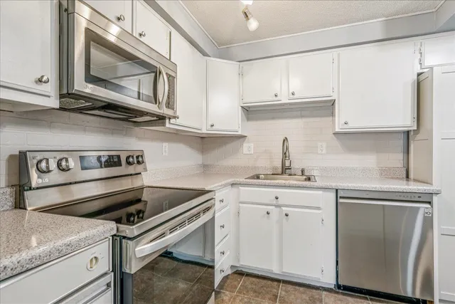 a kitchen with stainless steel appliances granite countertop a sink and cabinets