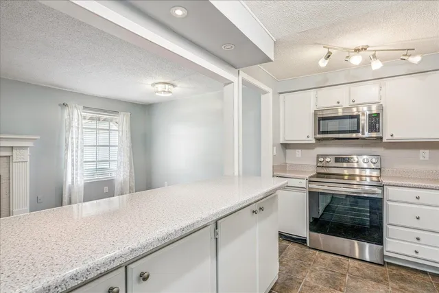 a kitchen with stainless steel appliances a stove microwave and sink