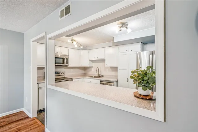 a large white kitchen with a stove and a refrigerator