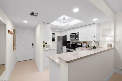 a large kitchen with a large counter top appliances and cabinets