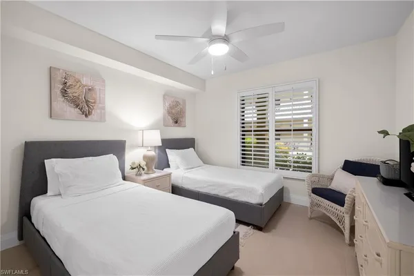 a bedroom with two beds and a chandelier