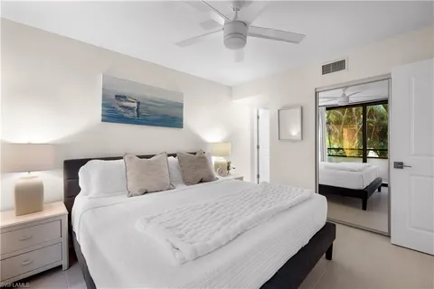 a bedroom with a bed and a large mirror