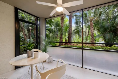a living room with a large window and dining table