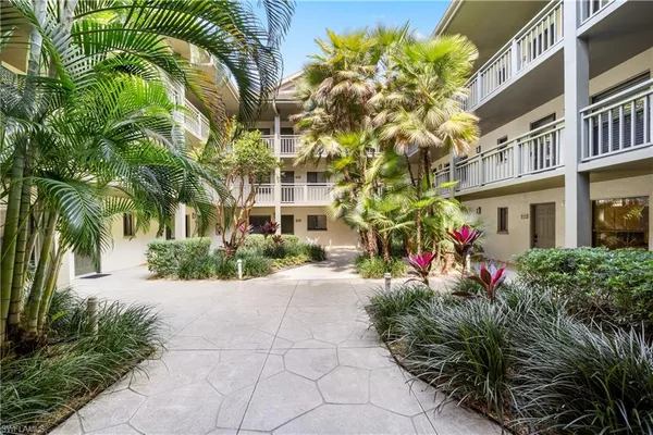a view of a multi story residential apartment building with a yard