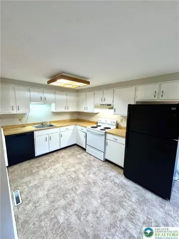 a kitchen with a cabinets and white appliances