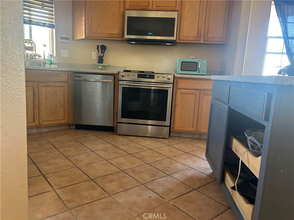 1301 West Willow Avenue Ridgecrest, CA 93555 - Photo 11 of 12 a kitchen with granite countertop a stove top oven a sink a counter space and cabinets