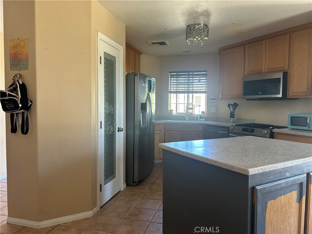 1301 West Willow Avenue Ridgecrest, CA 93555 - Photo 12 of 12 a kitchen with a sink and a refrigerator