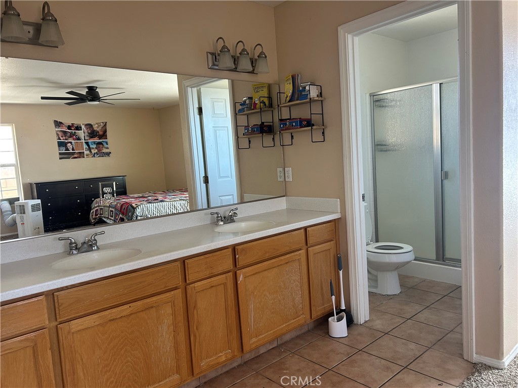 1301 West Willow Avenue Ridgecrest, CA 93555 - Photo 5 of 12 a bathroom with a granite countertop sink toilet and shower