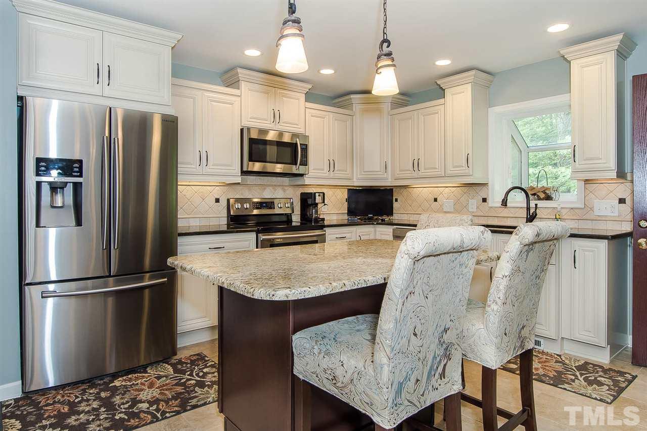 4212 Pickwick Drive Raleigh, NC 27613 - Photo 2 of 8 a kitchen with stainless steel appliances granite countertop a sink a stove a refrigerator cabinets and chairs