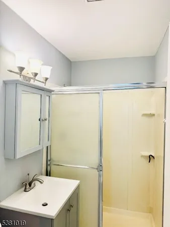 a bathroom with a sink mirror and shower