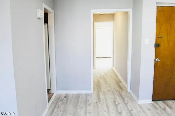 a view of a room that has a bed and wooden floor