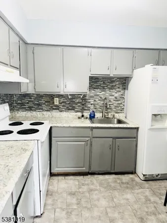 a kitchen with granite countertop a sink and a stove