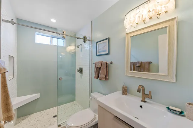 a bathroom with a sink a toilet and shower