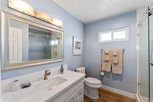 a bathroom with a sink vanity mirror and toilet