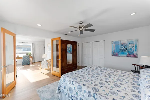 a bedroom with a large bed a flat tv screen and furniture