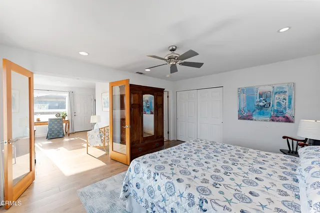 a bedroom with a large bed a flat tv screen and furniture