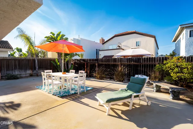 a patio with a table and chairs under an umbrella