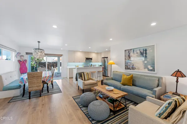a living room with furniture and a dining table with wooden floor
