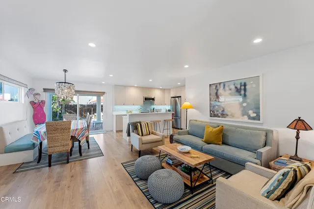 a living room with furniture and a dining table with wooden floor
