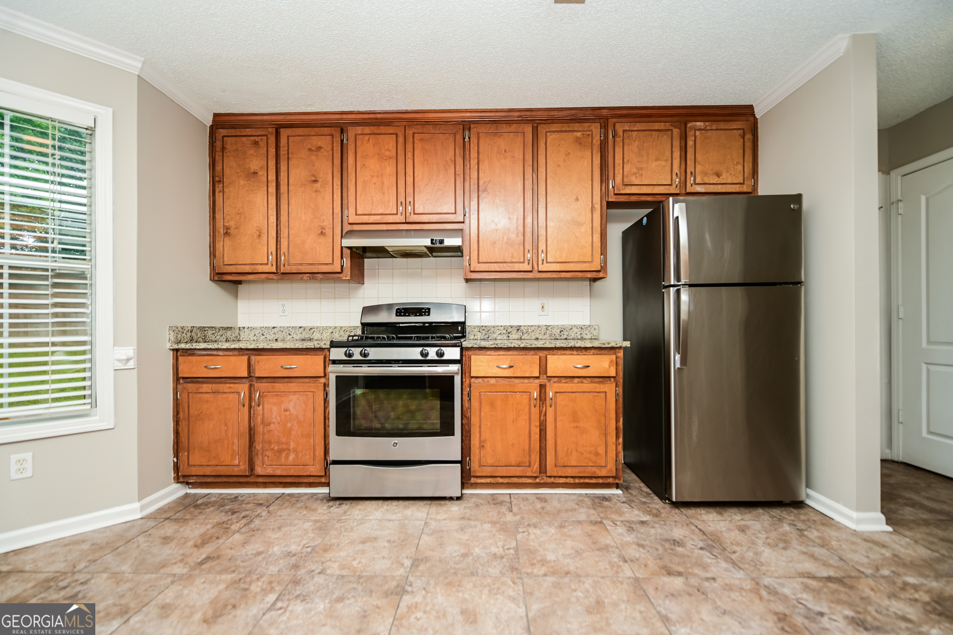 10253 Commons Crossing Jonesboro, GA 30238 - Photo 5 of 17 a kitchen with a refrigerator and a stove