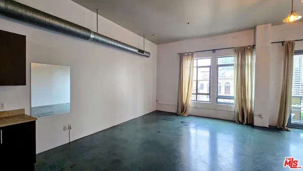 a view of a livingroom with wooden floor and a window