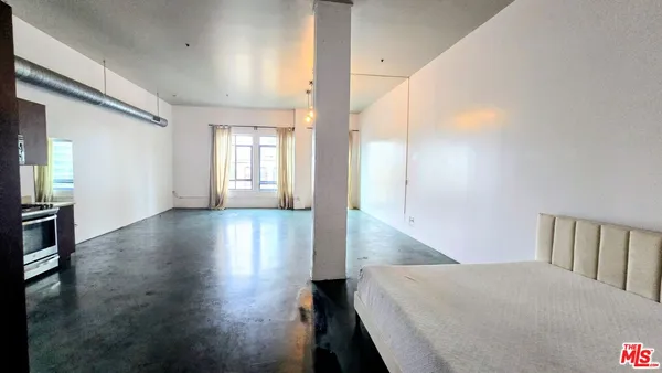 a view of a hallway with wooden floor and windows