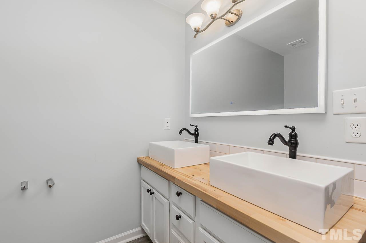 5708 Brandycrest Drive Raleigh, NC 27610 - Photo 13 of 31 a bathroom with a sink and a mirror