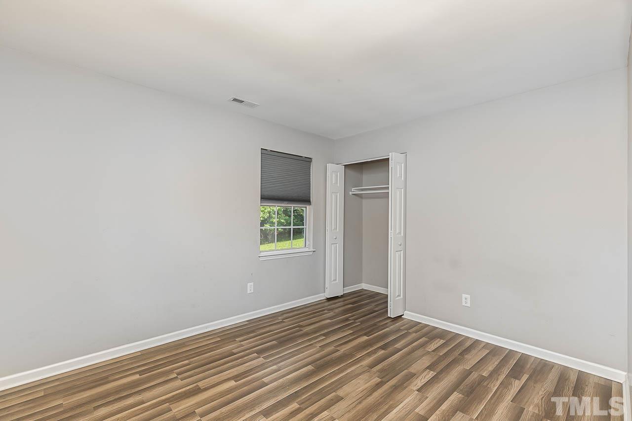5708 Brandycrest Drive Raleigh, NC 27610 - Photo 16 of 31 a view of an empty room with wooden floor and a window