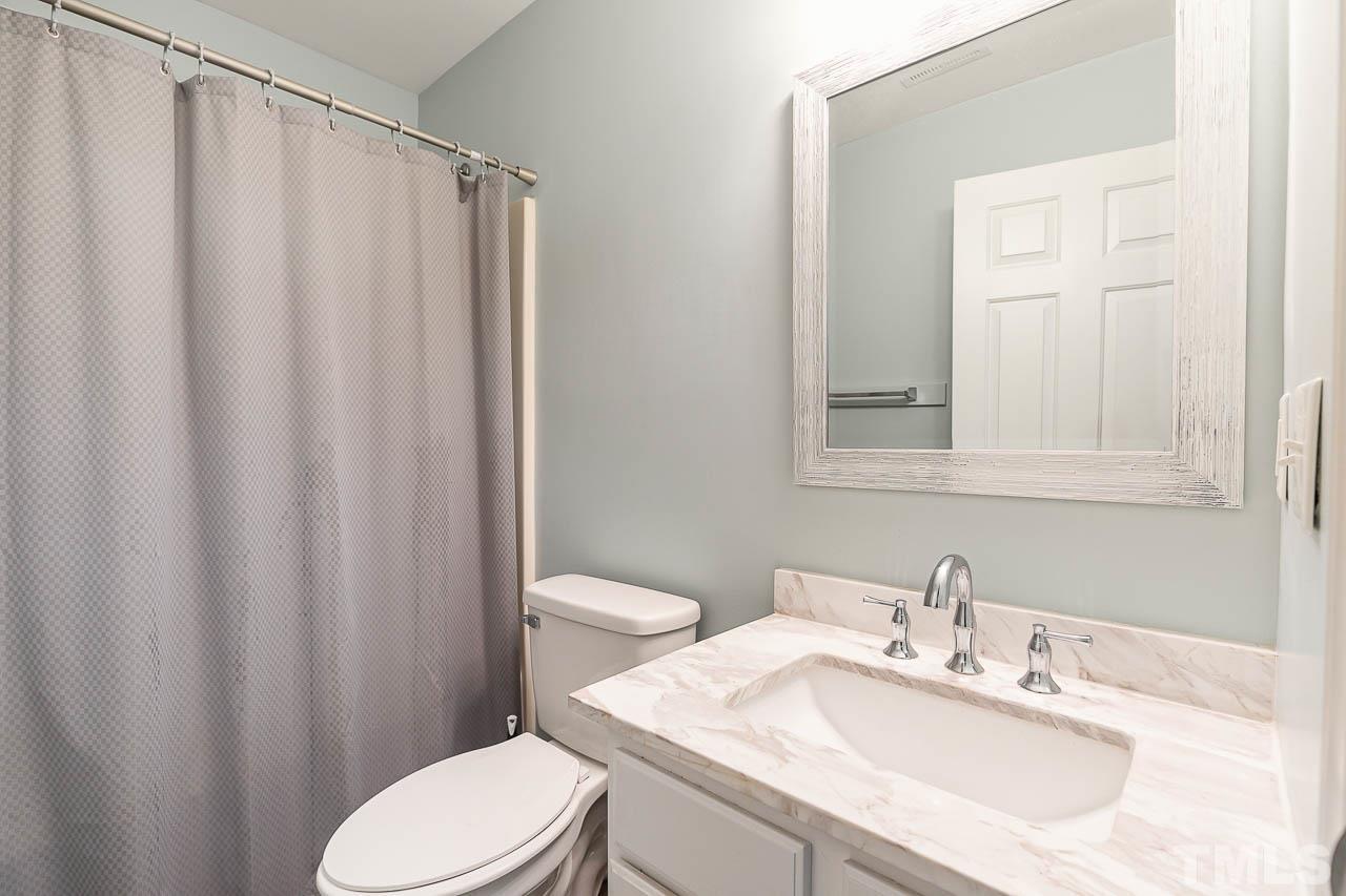 5708 Brandycrest Drive Raleigh, NC 27610 - Photo 20 of 31 a bathroom with a sink a toilet and shower curtain