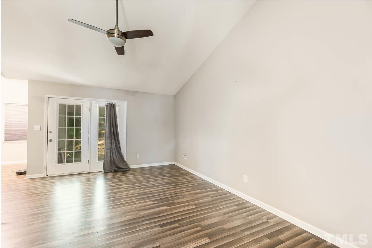 5708 Brandycrest Drive Raleigh, NC 27610 - Photo 7 of 31 a view of an empty room with wooden floor and a window