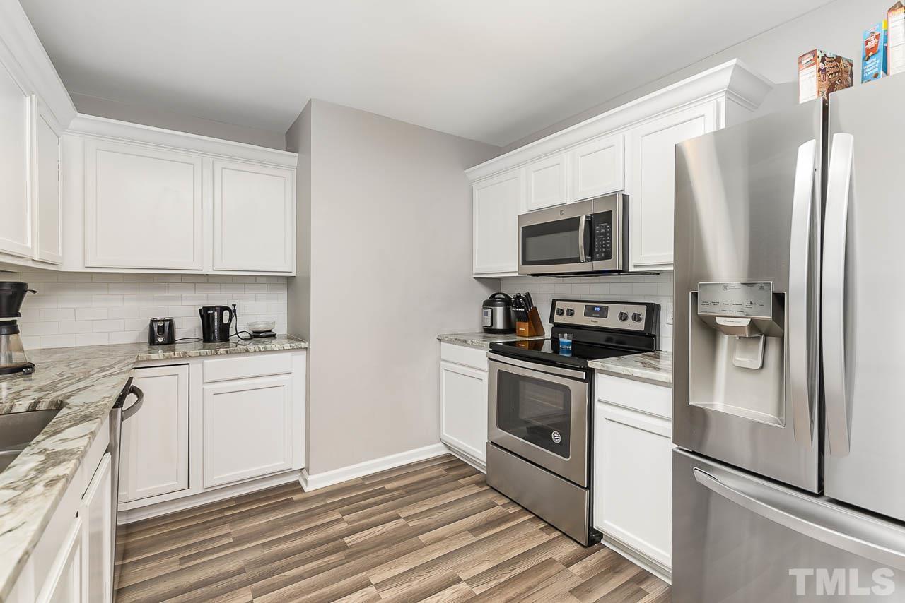 5708 Brandycrest Drive Raleigh, NC 27610 - Photo 9 of 31 a kitchen with stainless steel appliances granite countertop a stove a refrigerator and a microwave